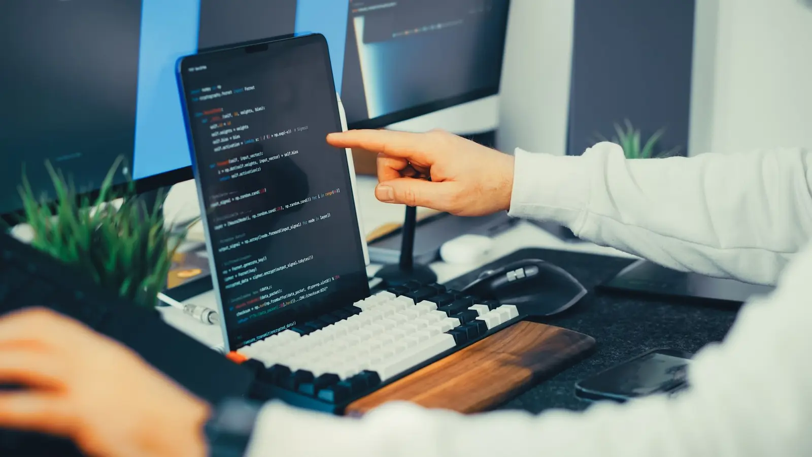 Programmer typing code on a laptop.