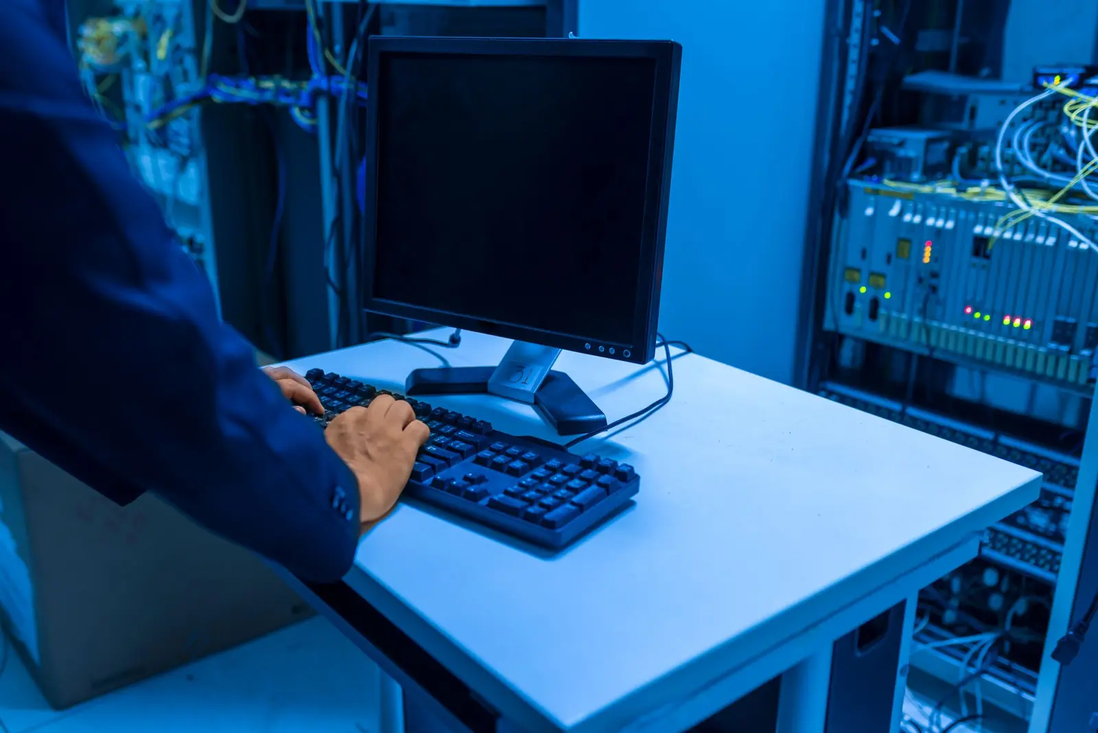 Engineer standing beside enterprise server racks.